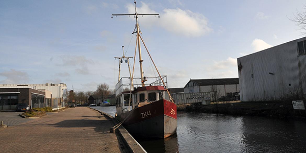 Voormalig vissersschip gestrand bij brug Dokkum